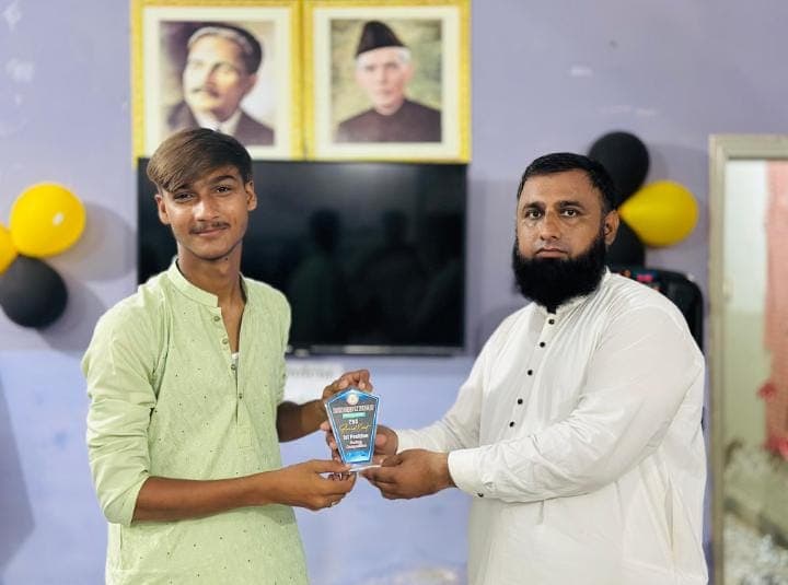 A student receives an award shield at the ceremony