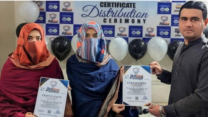 Two students with their certificates at the ceremony